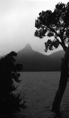 On a cold morning of grey skies and low cloud, the pinnacle of Mt Ida risis into the mist. Photographed from Echo Point on the western shore of Lake St Clair, the mountain is in the Cradle Mountain-Lake St Clair National Park.