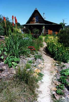 Oot of sight to the left of the house is a wind turbine and a photovoltaic array that charges a set of battries. The food garden is to the right of the house.