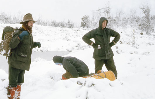 With the woman doubled in pain, the party stop to discuss what to do. 