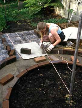 mont_measuring Using a stringline to measure the placement of recycled bricks to edge the garden path around a circular bed. Fiona's bckground in the design professions taught her the importance of accuracy in making durable gardens.